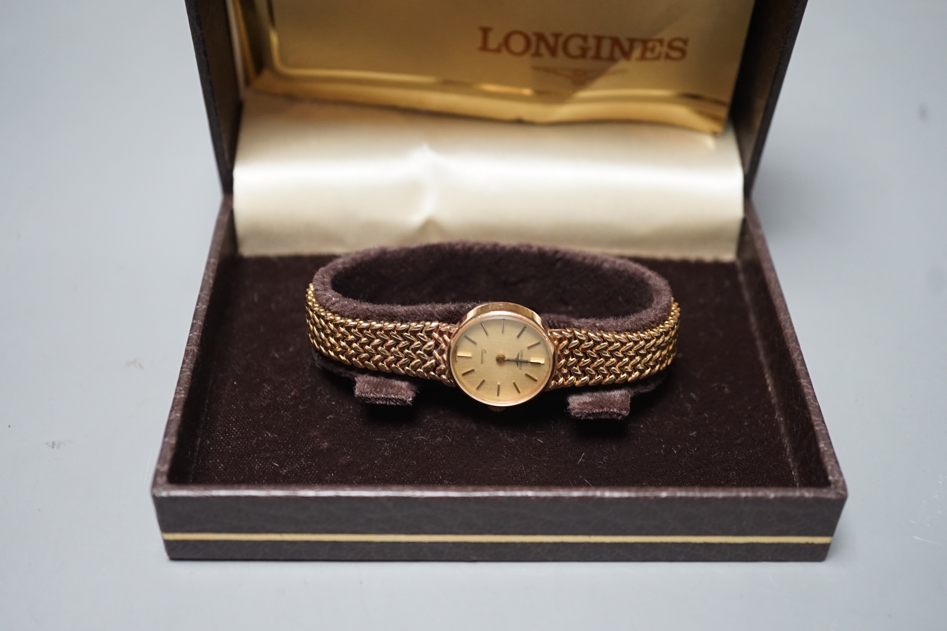 A lady's 9ct gold Longines quartz wrist watch on an inegral 9ct gold bracelet, with Longines box